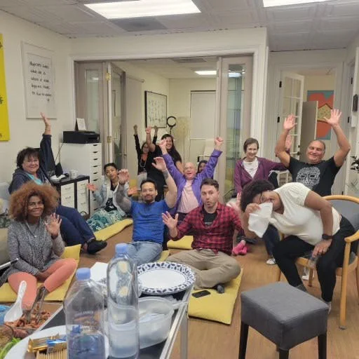 San Diego Meditation Center members cheering together at a community potluck