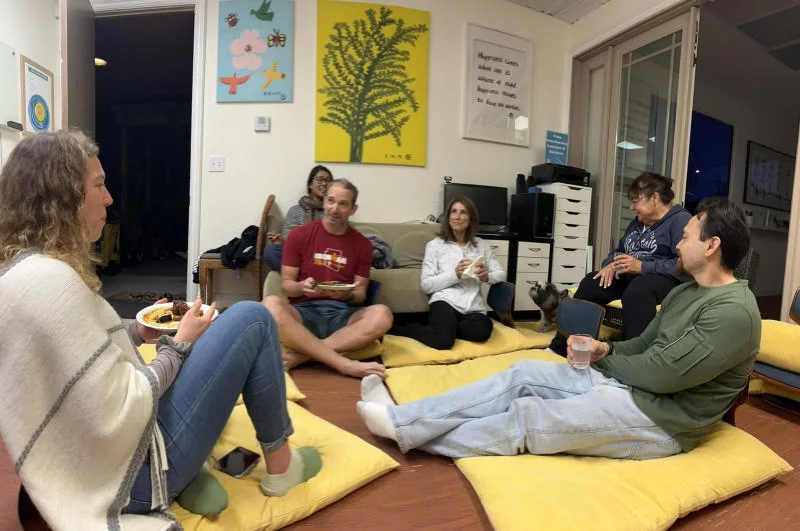 Members in conversation on the meditation center's floor cushions